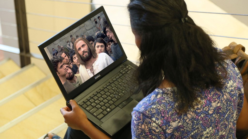 Woman watching the Jesus Film on her laptop. Image taken from behind.