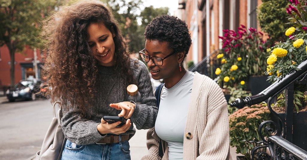 two women looking at phone together