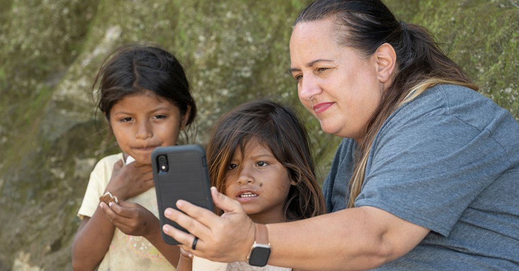 woman showing 2 kids a phone